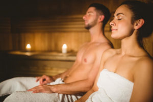 man and woman seated in infrared sauna