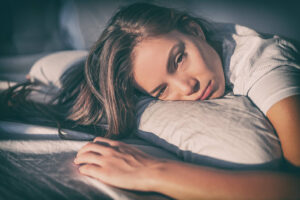young woman with chronic fatigue lying on bed