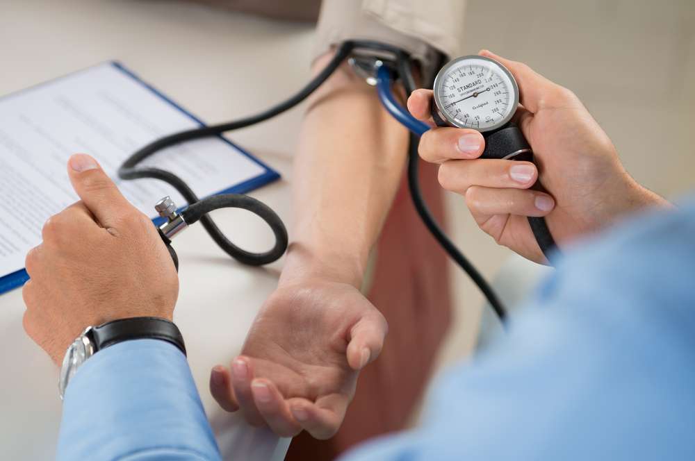 doctor checking person's blood pressure