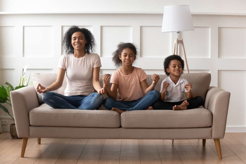 mother and 2 kids sitting on couch practicing mindfulness