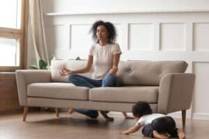 African American woman sitting on couch cultivating mindfulness