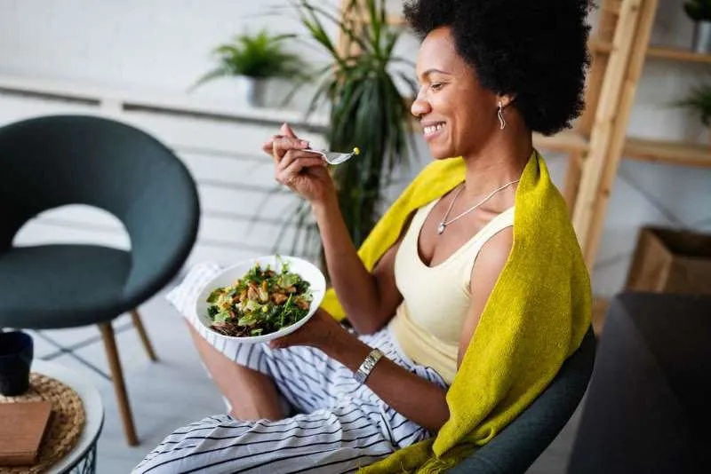 smiling woman enjoying a healthy salad