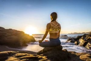 Woman,Training,Yoga,On,The,Beach,At,Sunset